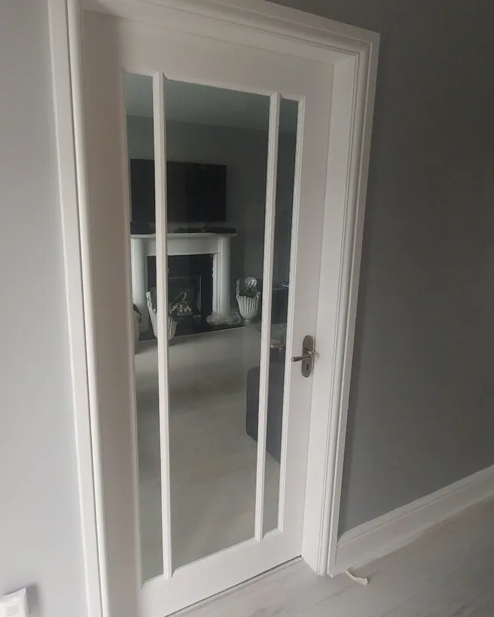 a white door with a mirror on the side of it