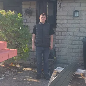 A man standing in front of a house.